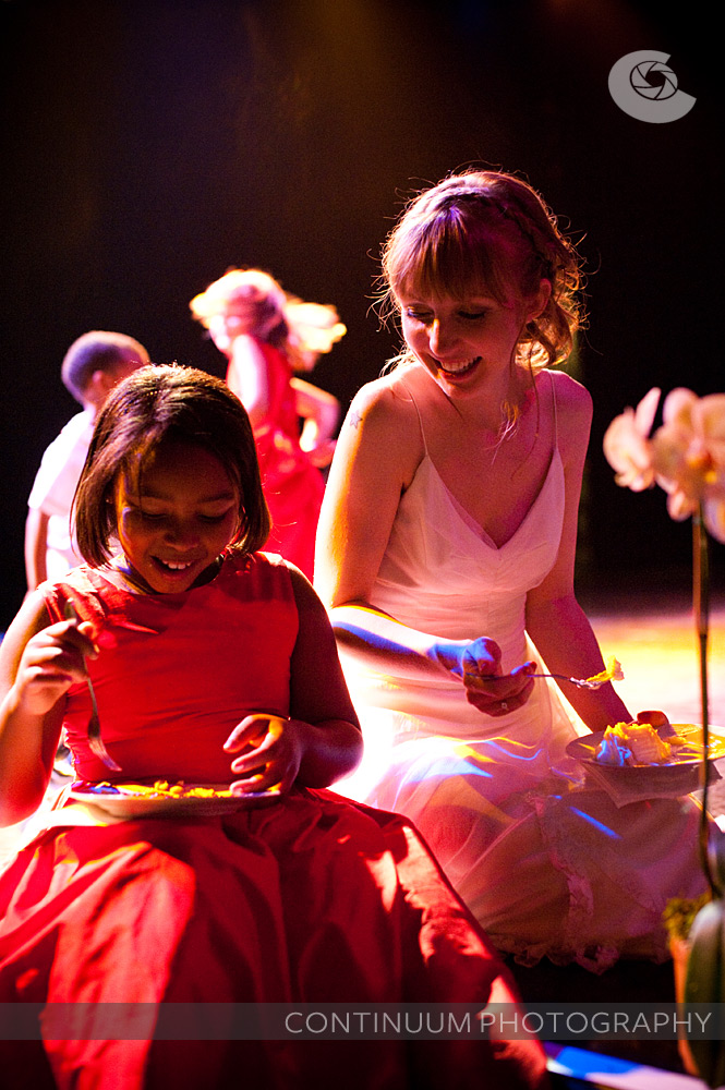 a bride enjoys a slice of wedding pie with a young guest